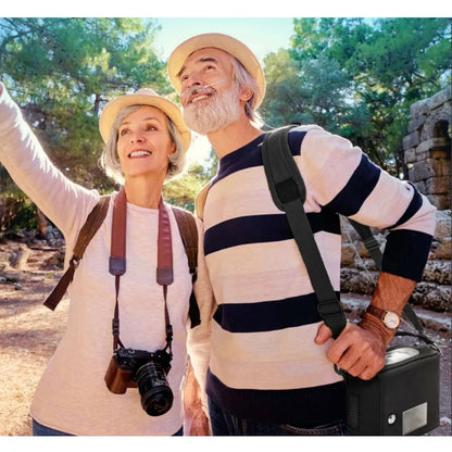 Two older adults on a hike with backpacks and camera, surrounded by nature. The man is using a nasal cannula and wearing a Kingon P2 portable oxygen concentrator shoulder carry bag.