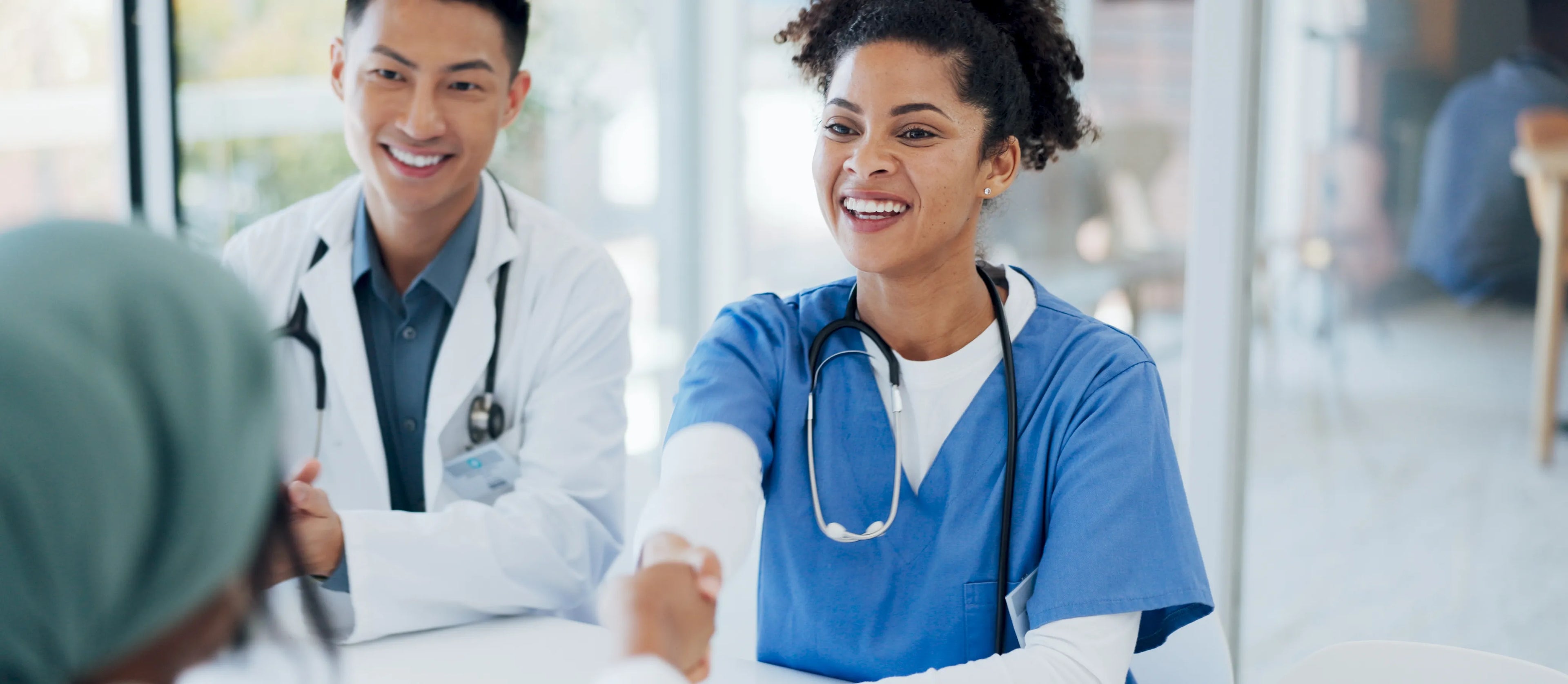 Doctor and nurse handshaking a patient.