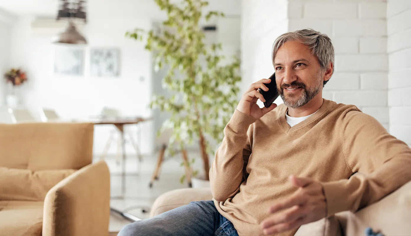 Man on the phone, smiling and looking into the distance.