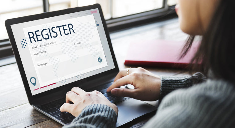 Woman typing in a registration form on a laptop.